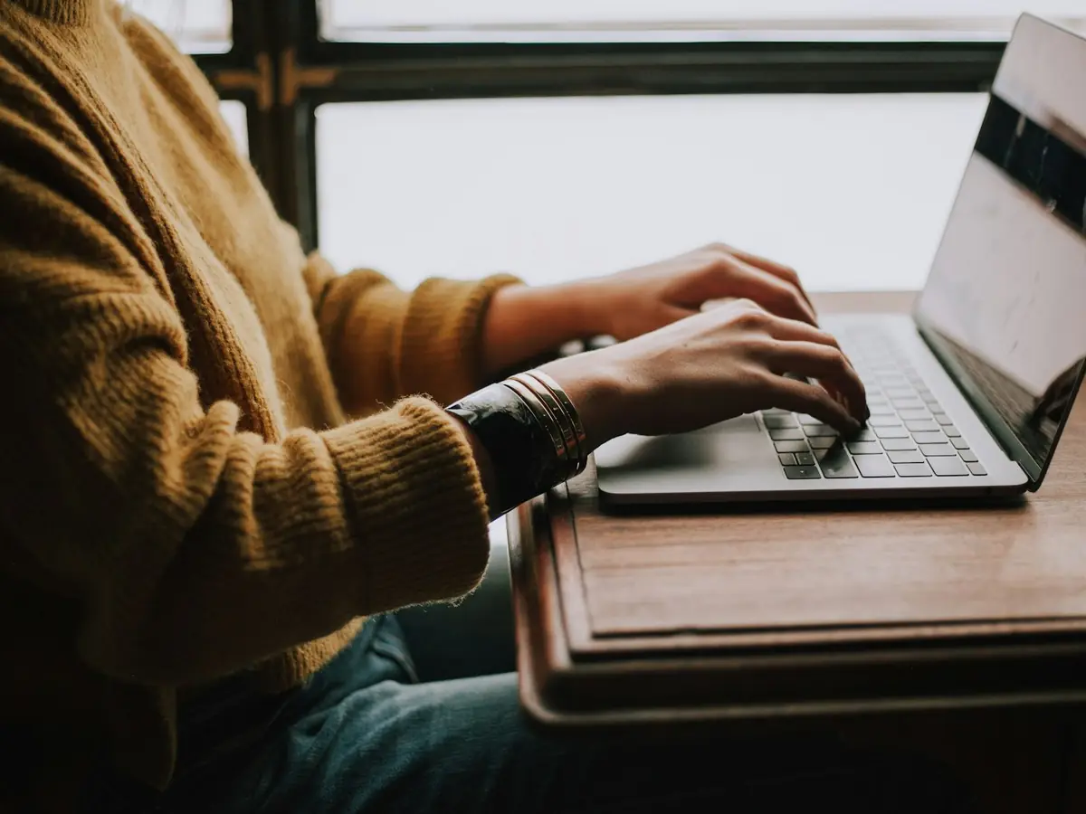 Hände tippen auf einem Laptop – Webdesign-Arbeit